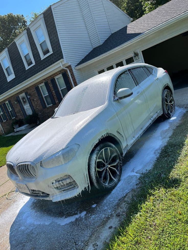 White BMW X4 covered in foam during a full mobile detail